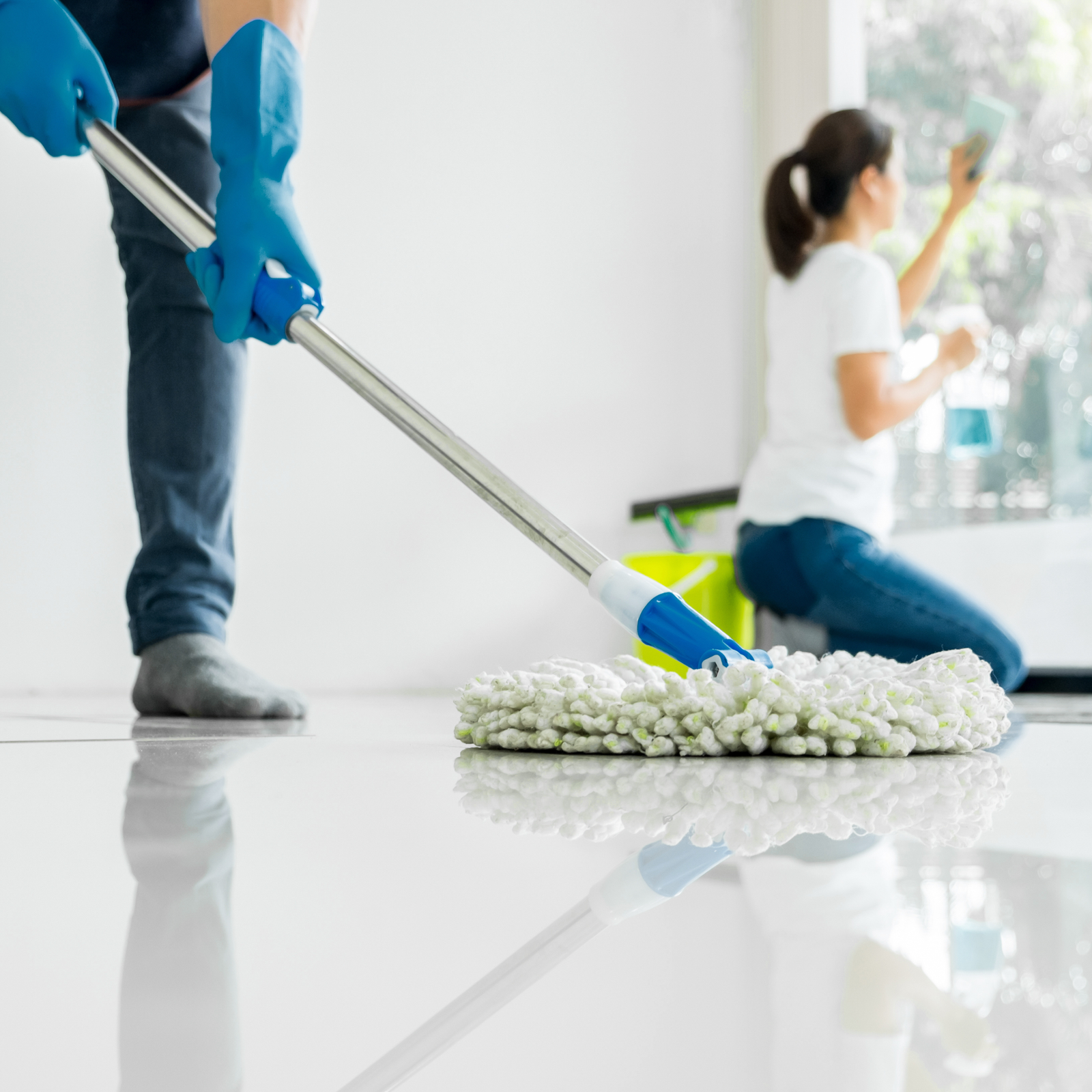 a man and woman cleaning with mop and brush